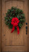 Christmas wreath with red bow and pinecones on a door